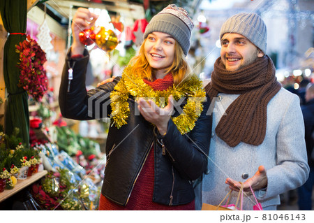 Girl with boy choosing decorations at Christmas market Girl with boy choosing decorations at Christmas market 81046143