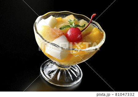 牛乳かんやパイン、マンゴー、白桃、チェリー、ミカンなどのフルーツが入ったフルーツポンチを黒背景で撮影 81047332