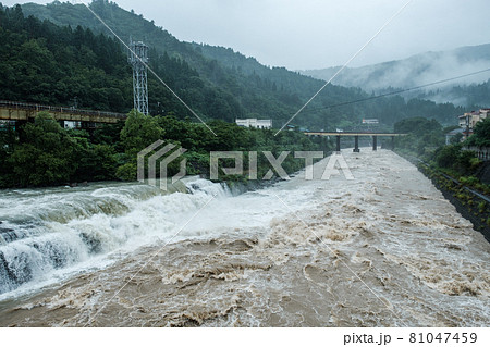 大雨で増水した川 81047459