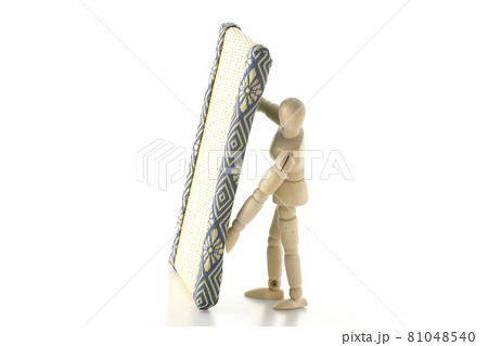 デッサン人形が畳を持ち上げる様子を白背景で撮影の写真素材