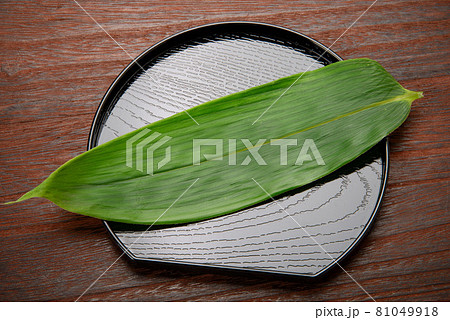 料理、食物等の背景用の笹を乗せた半月盆 料理、食物等の背景用の笹を乗せた半月盆 81049918