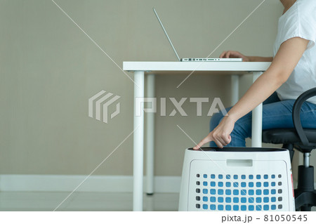 Woman using air purifier while staying in living room. 81050545
