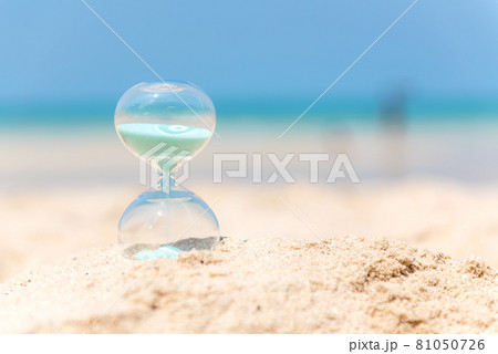 Hourglass summer and vacations time on a beach in the sand with blue sky and copy space. Hourglass summer and vacations time on a beach in the sand with blue sky and copy space. 81050726