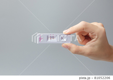 man holding Rapid Antigen Test kit with Positive result during swab COVID-19 testing. Coronavirus Self nasal or Home test, Lockdown and Home Isolation concept 81052206