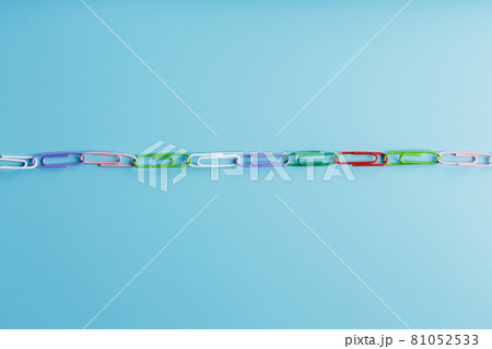 Interlocked colored paper clips in a line on a blue background with free space Interlocked colored paper clips in a line on a blue background with free space 81052533