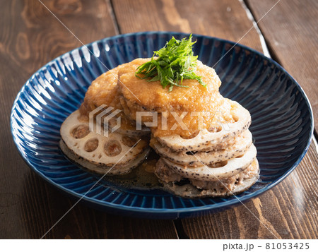蓮根料理。蓮根でミンチ肉を挟んでこんがり焼いた料理に大葉とソースをトッピング。 蓮根料理。蓮根でミンチ肉を挟んでこんがり焼いた料理に大葉とソースをトッピング。 81053425