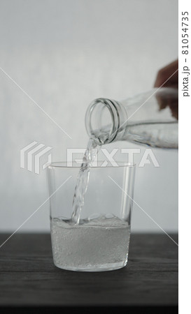 Vertical shot of making espresso tonic in tumbler glass, pour tonic 81054735