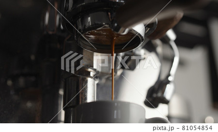 Low angle of pulling espresso shot with naked portafilter Low angle of pulling espresso shot with naked portafilter 81054854