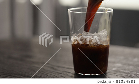 Making espresso tonic in tumbler glass, pour espresso in glass with crushed ice 81054881