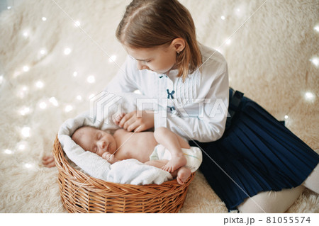 happy girl looking at her newborn sister . 81055574