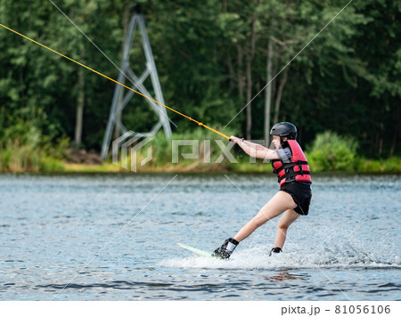 Wake boarding boy on lake, the forest in blurry background. Wake boarding boy on lake, the forest in blurry background. 81056106