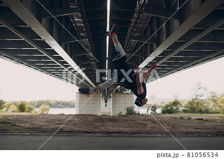Young sporty guy doing parkour at the city street. Young sporty guy doing parkour at the city street. 81056534