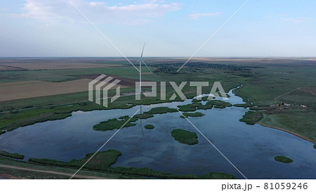 Wind turbine on the shore of the lake. Evening time. Wind turbine on the shore of the lake. Evening time. 81059246