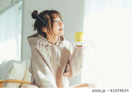 部屋で音楽を聴く女性 81059634