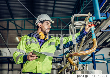 Young hispanic latin engineer working in a heavy industrial factory. worker control oil gas water pipe in plant. 81060904