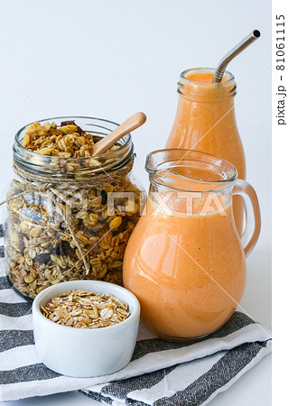 Seasonal pumpkin carrot smoothie drink detox with eco metal drinking straw Glass jar granola muesli oatmeal breakfast. Orange smoothie. Clean eating, weight loss, healthy dieting food concept 81061115