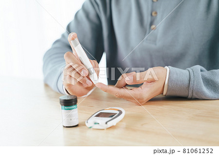 Man using lancet on finger for checking blood sugar level by Glucose meter, Healthcare and Medical, diabetes, glycemia concept 81061252