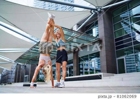 Two women doing exercise outdoors in city, healthy lifestyle concept. 81062069