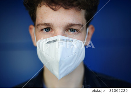 Headshot portrait of young man with respirator against green background outdoors, coronavirus concept. Headshot portrait of young man with respirator against green background outdoors, coronavirus concept. 81062226