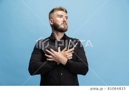 Portrait of funny bearded man, builder, designer or architect with professional equipment isolated on blue studio background. Portrait of funny bearded man, builder, designer or architect with professional equipment isolated on blue studio background. 81064835