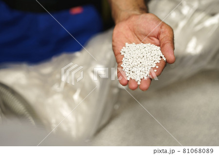 Close up of male hand holding plastic polymer granules 81068089