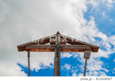 Wooden crucifixion of Jesus Christ on a background of blue sky with clouds. Wooden crucifixion of Jesus Christ on a background of blue sky with clouds. 81068687