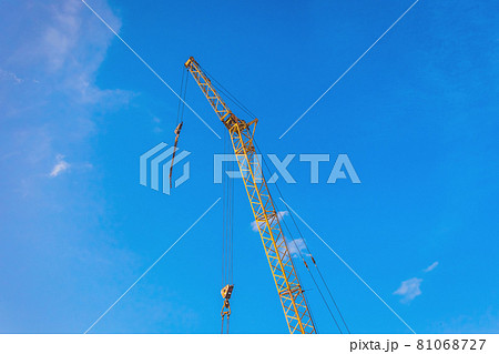 Hoisting machine industrial crane equipment against blue sky at construction site Hoisting machine industrial crane equipment against blue sky at construction site 81068727