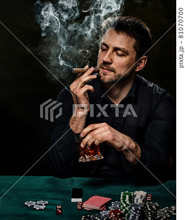 Bearded casino player man playing poker on green table Bearded casino player man playing poker on green table 81070700