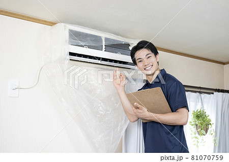 エアコンの清掃後に清潔さをアピールするハウスクリーニングの作業員 81070759