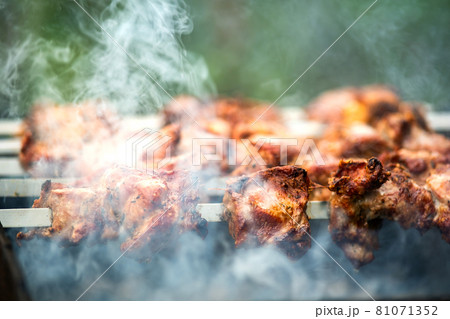 Shashlik or shish kebab preparing on barbecue grill over hot charcoal. Grilled pieces of pork meat on metal skewers. Shashlik or shish kebab preparing on barbecue grill over hot charcoal. Grilled pieces of pork meat on metal skewers. 81071352