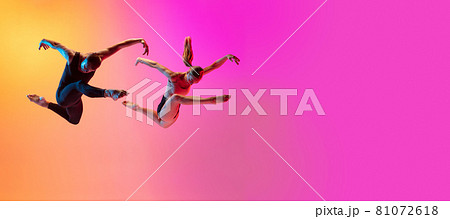 Two dancers, stylish sportive couple, male and female models dancing contemporary dance on colorful gradient yellow pink background in neon light. Two dancers, stylish sportive couple, male and female models dancing contemporary dance on colorful gradient yellow pink background in neon light. 81072618