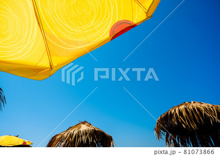 Yellow sun umbrellas and blue sky at the beach. 81073866