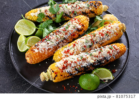 Elotes, Grilled Mexican Street Corn on a plate 81075317