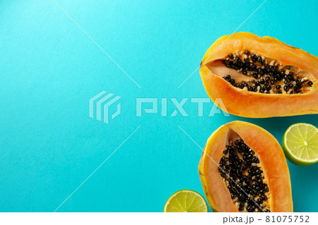 Summer composition. Tropical lime and papaya fruit cut in half lie on a blue background. Summer concept. Flat lay, top view, copy space 81075752