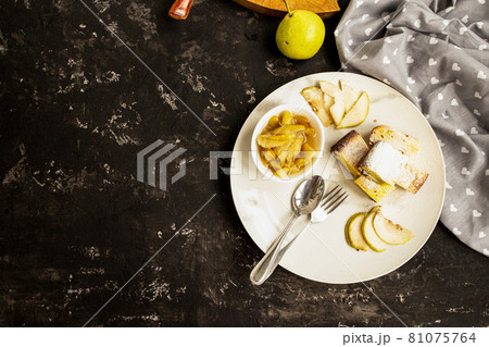 Pear jam and pie are on a white plate. Black background. Copy space. Sweet breakfast and snack. 81075764