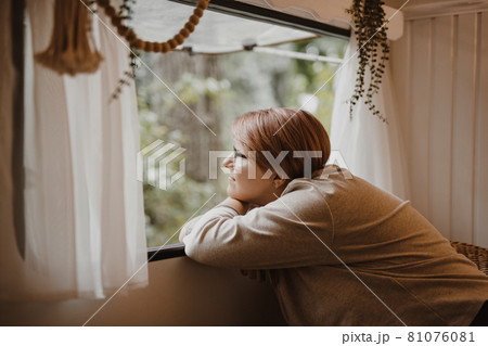 Cheerful dreamy young woman in a van window in nature. 81076081