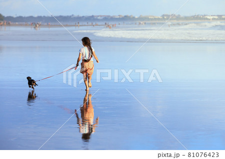 Girl have fun with dachshund dog, run by sea beach 81076423