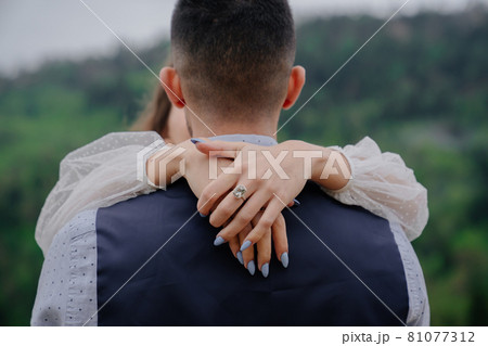 the bride and groom cuddling tenderly in nature. romance in the relationship the bride and groom cuddling tenderly in nature. romance in the relationship 81077312