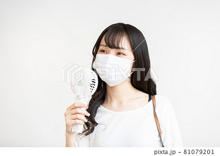 ハンディ扇風機を使う若い女性 ハンディ扇風機を使う若い女性 81079201