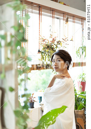 観葉植物のあるおしゃれな部屋に住む女性 81079451