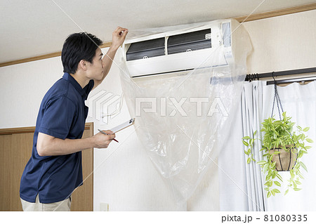 エアコンの清掃後に点検するハウスクリーニングの作業員 81080335