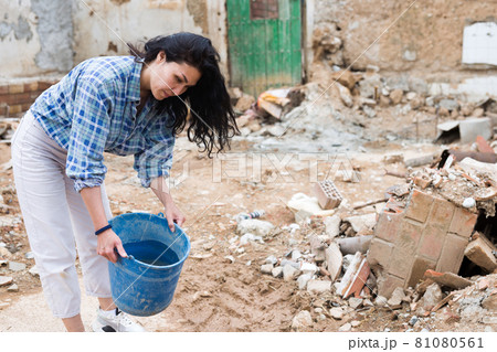 Woman near ruined house Woman near ruined house 81080561