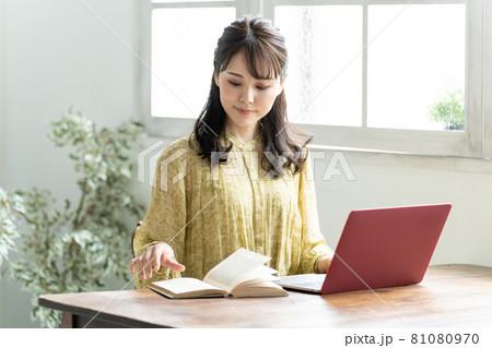 パソコンと本を使って勉強をする女性 パソコンと本を使って勉強をする女性 81080970