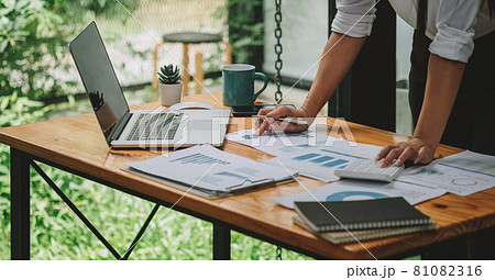 Business woman discussing on stockmarket charts in office, working on laptop computer Business woman discussing on stockmarket charts in office, working on laptop computer 81082316