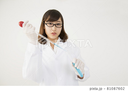 試験管にピペットで試薬を注ぐ白衣を着た若い女性 試験管にピペットで試薬を注ぐ白衣を着た若い女性 81087602