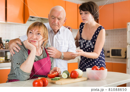 Daughter and husband calming upset aged woman 81088650