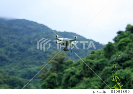 White drone with camera flying in summer mountains White drone with camera flying in summer mountains 81091399