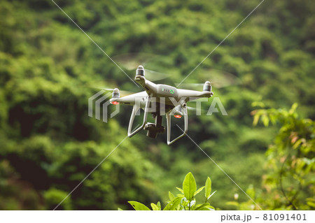 White drone with camera flying in summer mountains 81091401