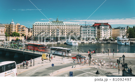Stockholm, Sweden - June 28, 2019: Traffic With Cars And Buses. Grand Hotel Located On The Peninsula Blasieholmen. Touristic Pleasure Boats Floating Near Famous Grand Hotel In Sunny Summer Day Stockholm, Sweden - June 28, 2019: Traffic With Cars And Buses. Grand Hotel Located On The Peninsula Blasieholmen. Touristic Pleasure Boats Floating Near Famous Grand Hotel In Sunny Summer Day 81092497