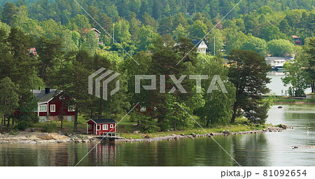 Many Red Swedish Wooden Sauna Logs Cabins Houses On Island Coast In Summer Cloudy Day Many Red Swedish Wooden Sauna Logs Cabins Houses On Island Coast In Summer Cloudy Day 81092654